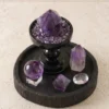 Amethyst point and sphere set on a dark wood tray