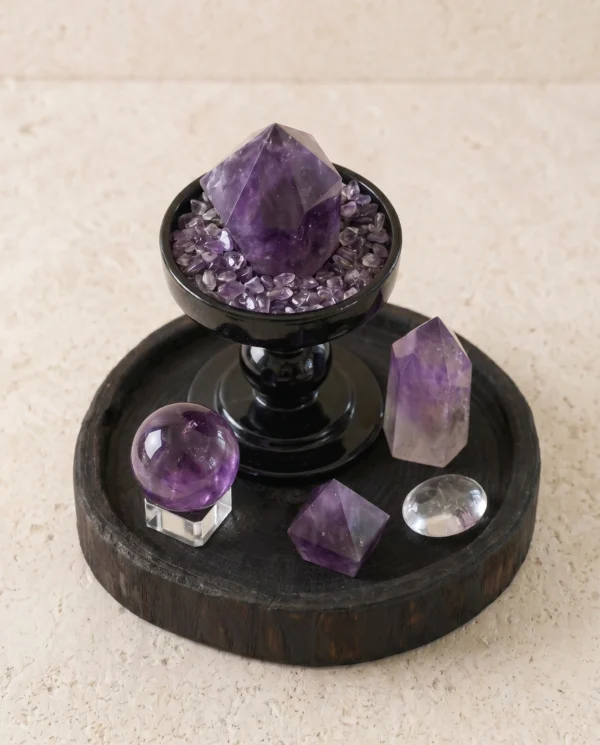 Amethyst point and sphere set on a dark wood tray
