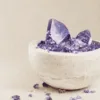 stone-blessings-amethyst-tower-and-chips-in-a-travertine-bowl-shown-from-an-angled-view-with-loose-amethyst-pieces-around-the-base Stone Blessings amethyst tower and chips in a travertine bowl shown from an angled view with loose amethyst pieces around the base