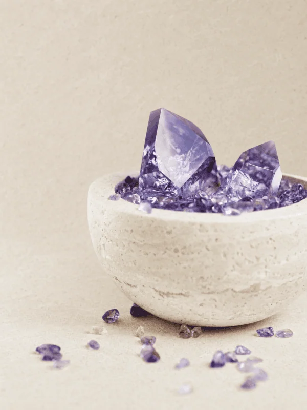 stone-blessings-amethyst-tower-and-chips-in-a-travertine-bowl-shown-from-an-angled-view-with-loose-amethyst-pieces-around-the-base Stone Blessings amethyst tower and chips in a travertine bowl shown from an angled view with loose amethyst pieces around the base