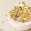 Stone Blessings citrine crystal bowl with a polished citrine tower and scattered citrine chips around a stone vessel