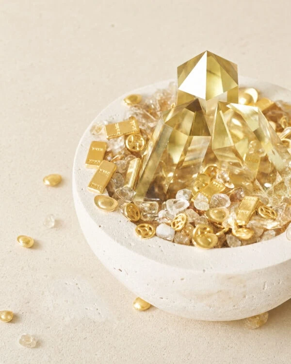 Stone Blessings citrine crystal bowl with a polished citrine tower and scattered citrine chips around a stone vessel