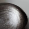 Stone Blessings close up of a natural volcanic obsidian sphere showing the polished black stone surface and subtle banding