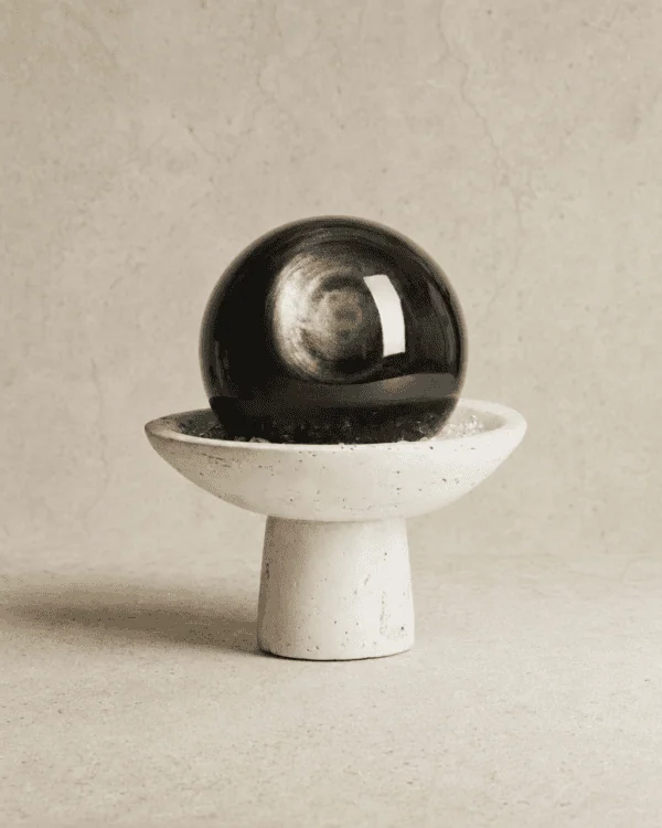 Stone Blessings natural volcanic obsidian sphere on a hand carved travertine pedestal bowl front view